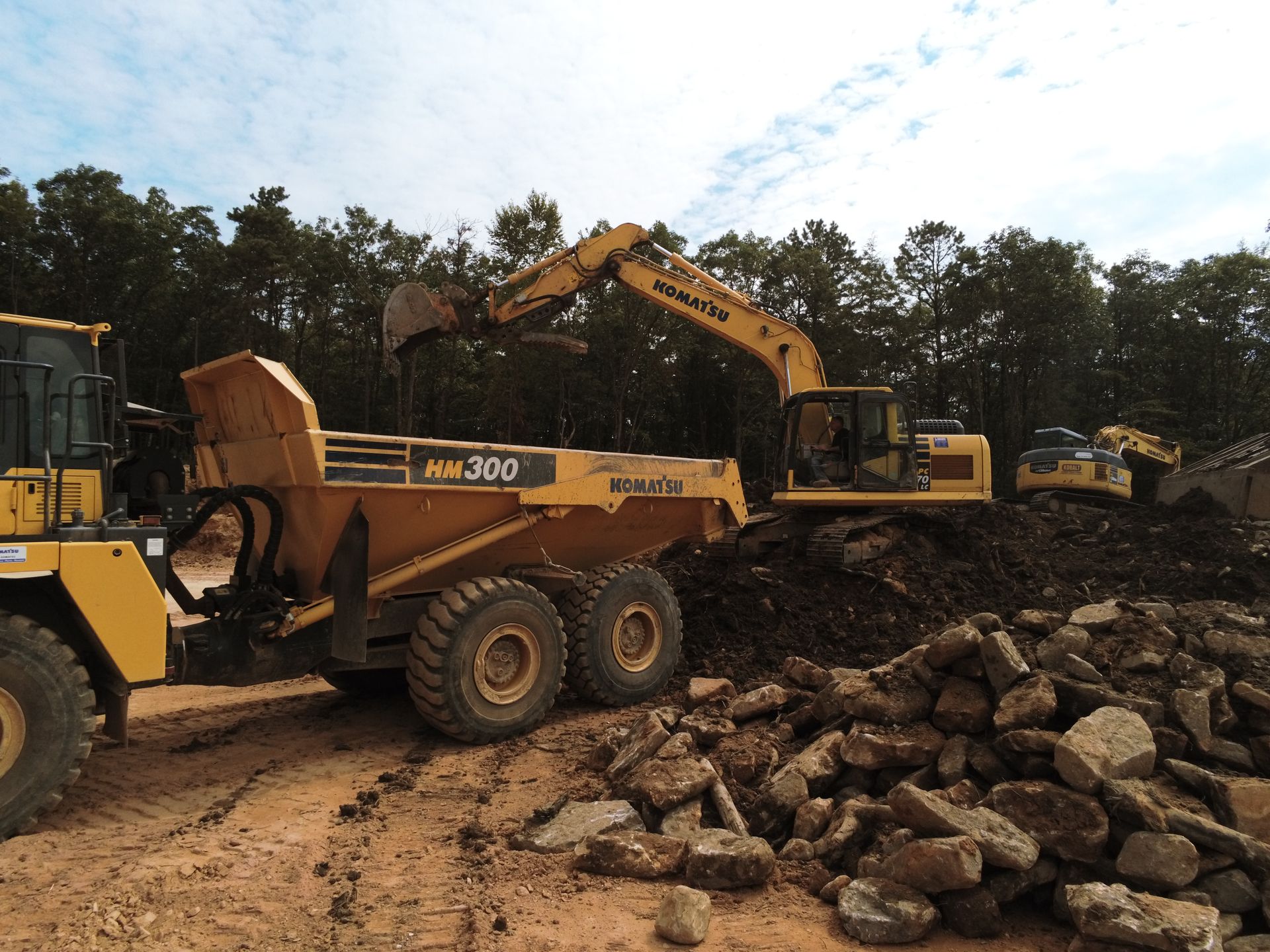 A komatsu dump truck is being loaded with rocks