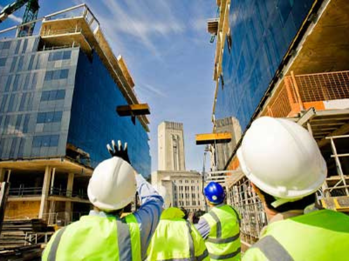 A group of construction workers are looking at a building under construction