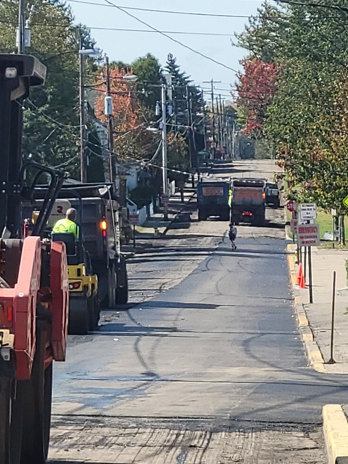 A row of trucks are driving down a street.