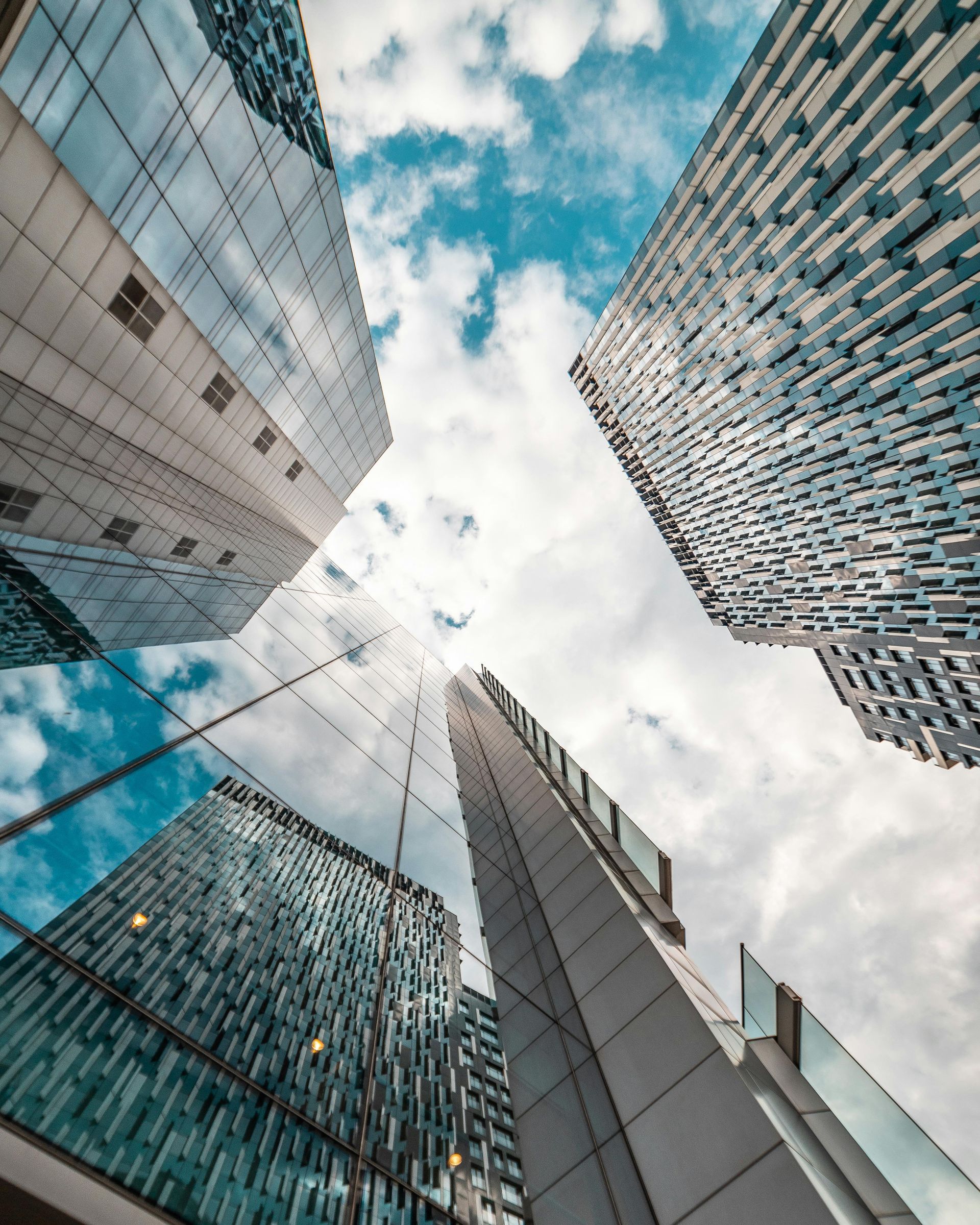 Looking up at a group of tall buildings with a blue sky in the background