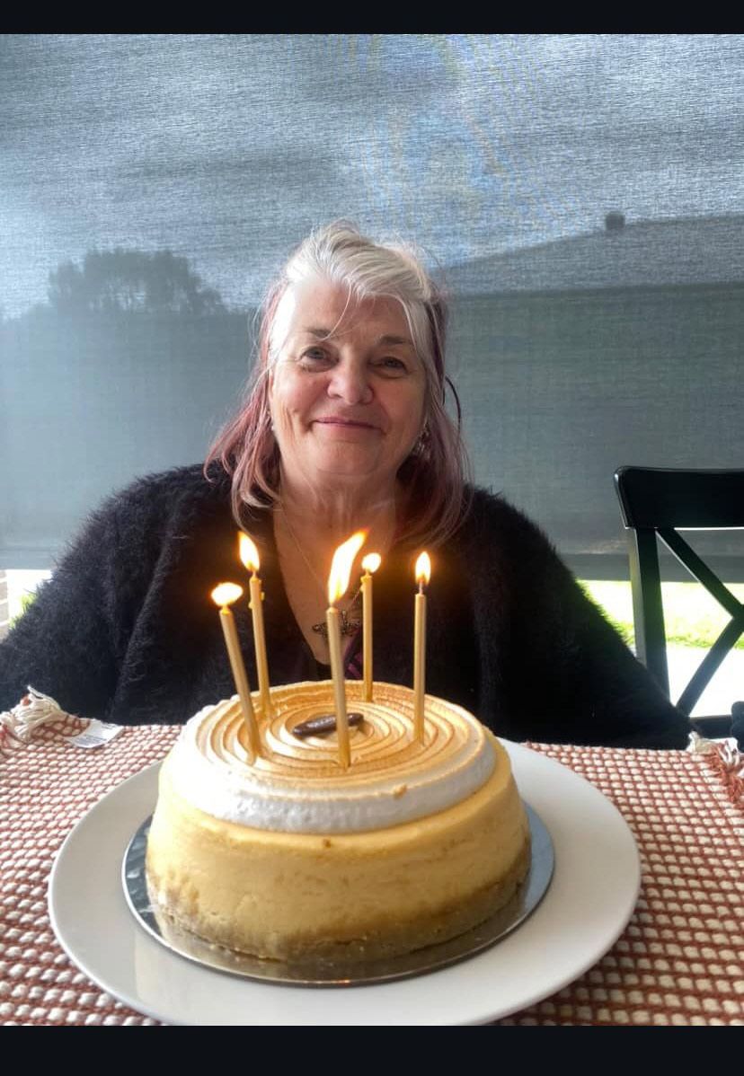 A Woman Is Sitting in Front of A Birthday Cake with Lit Candles — Medium in Bakery Hill, VIC