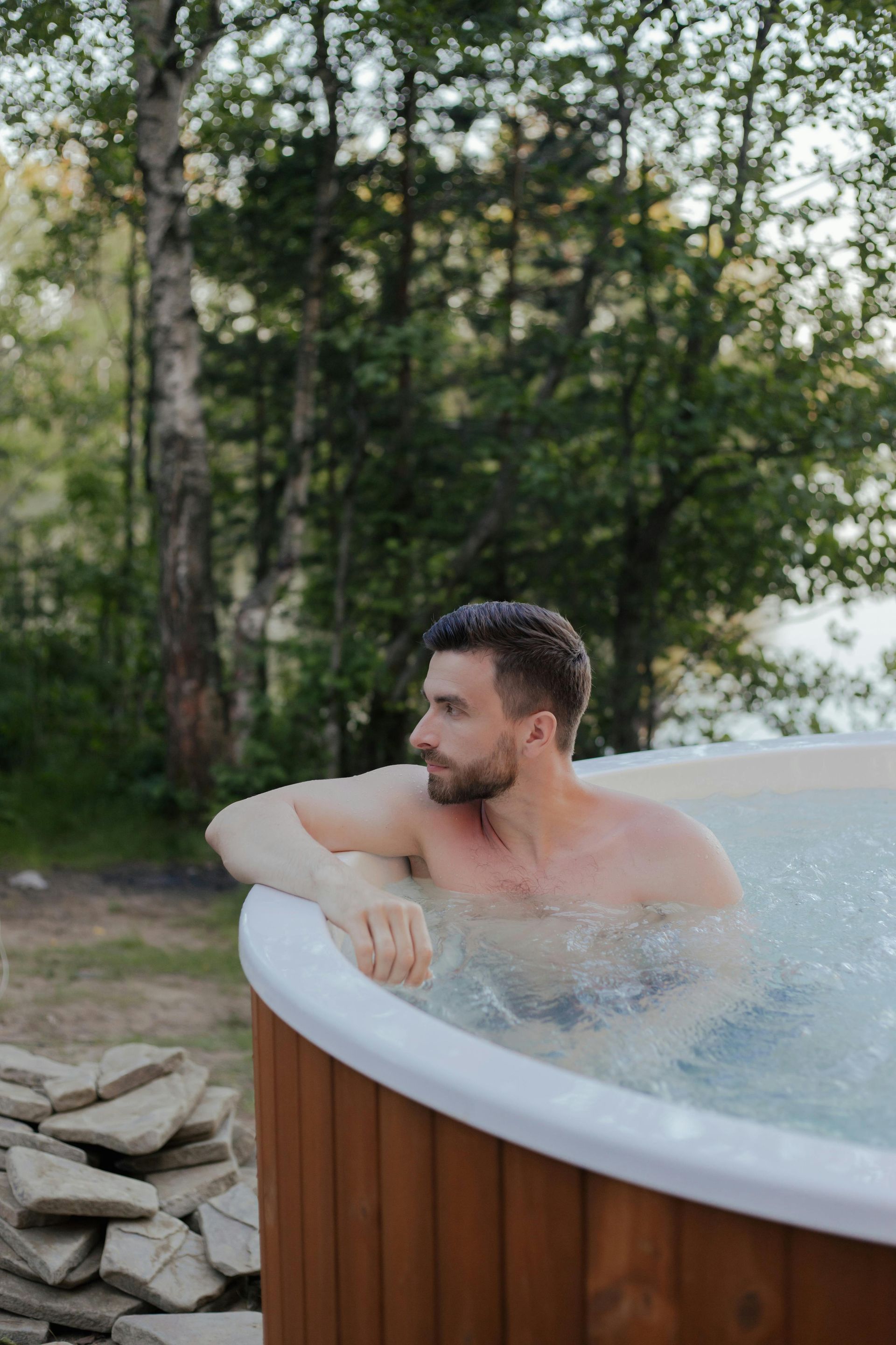 Hot tub with bubbling water in a spa-like room, with seating and greenery.