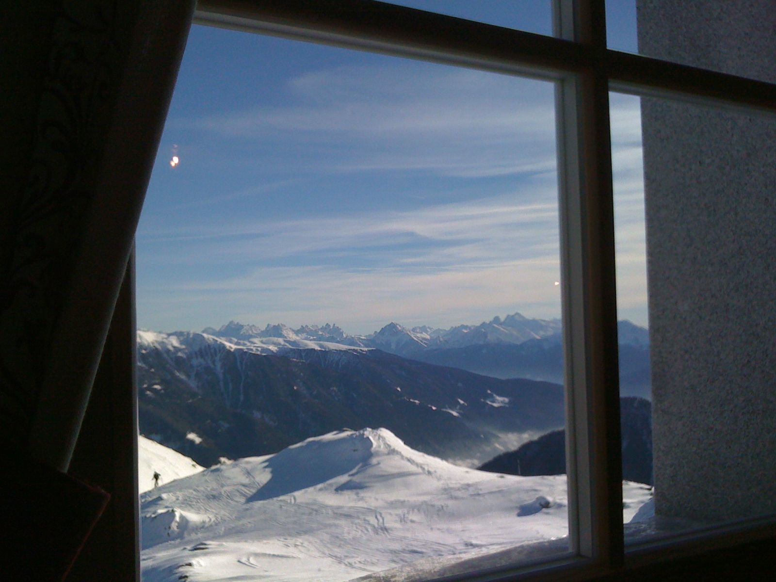Ein Fenster mit Blick auf eine schneebedeckte Bergkette