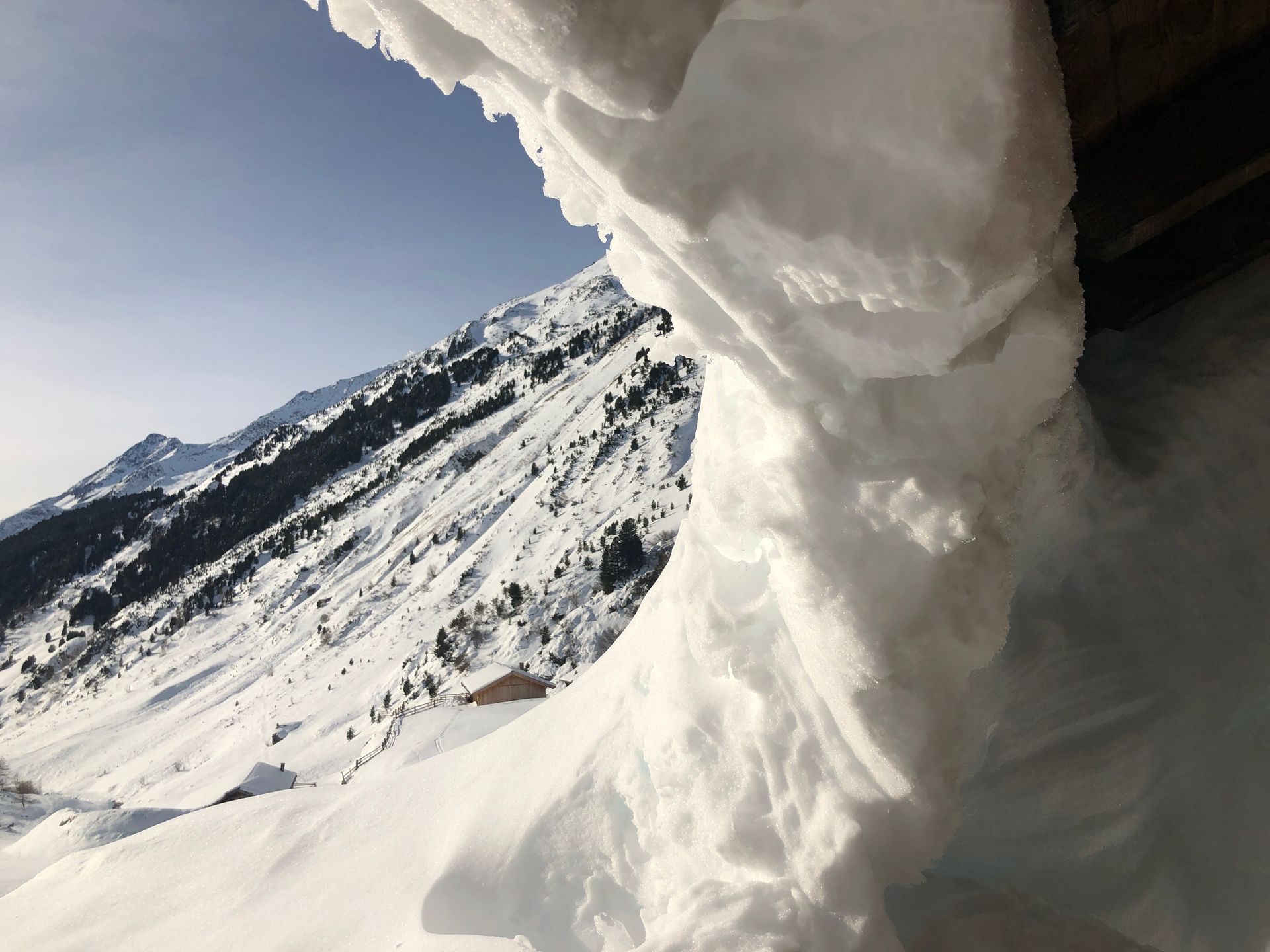 Auf der Spitze eines schneebedeckten Berges liegt ein großer Schneehaufen.