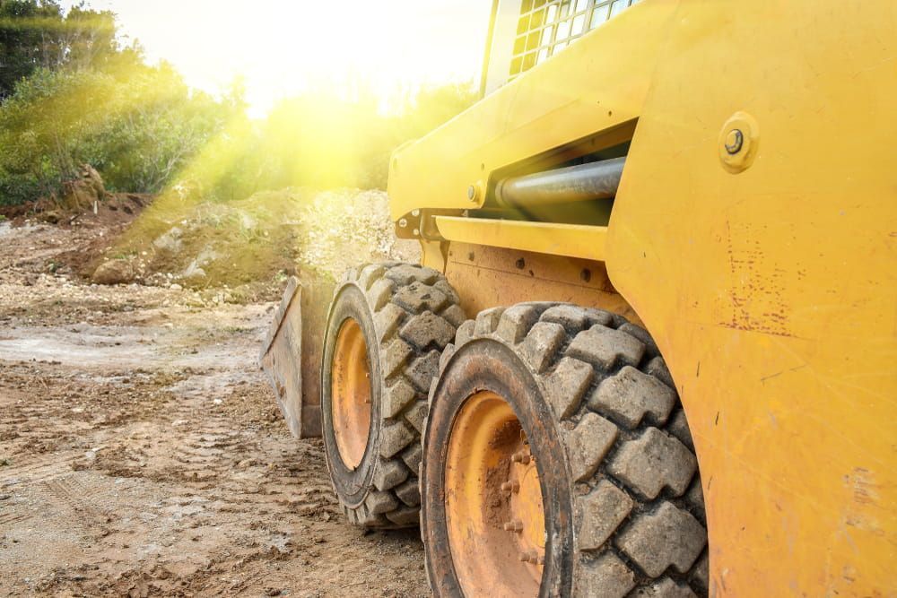 Yellow Skid Steer on a Dirt Road — Mini Excavator Hire in Cairns, QLD