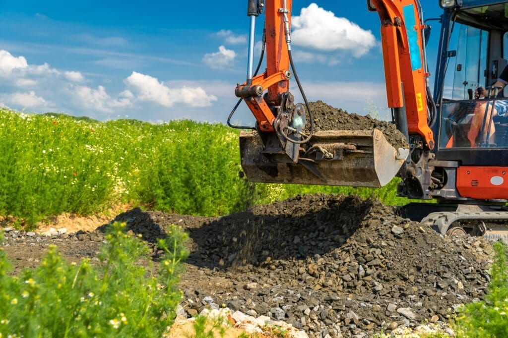 Orange Excavator Digging Soil — Mini Excavator Hire in Cairns, QLD