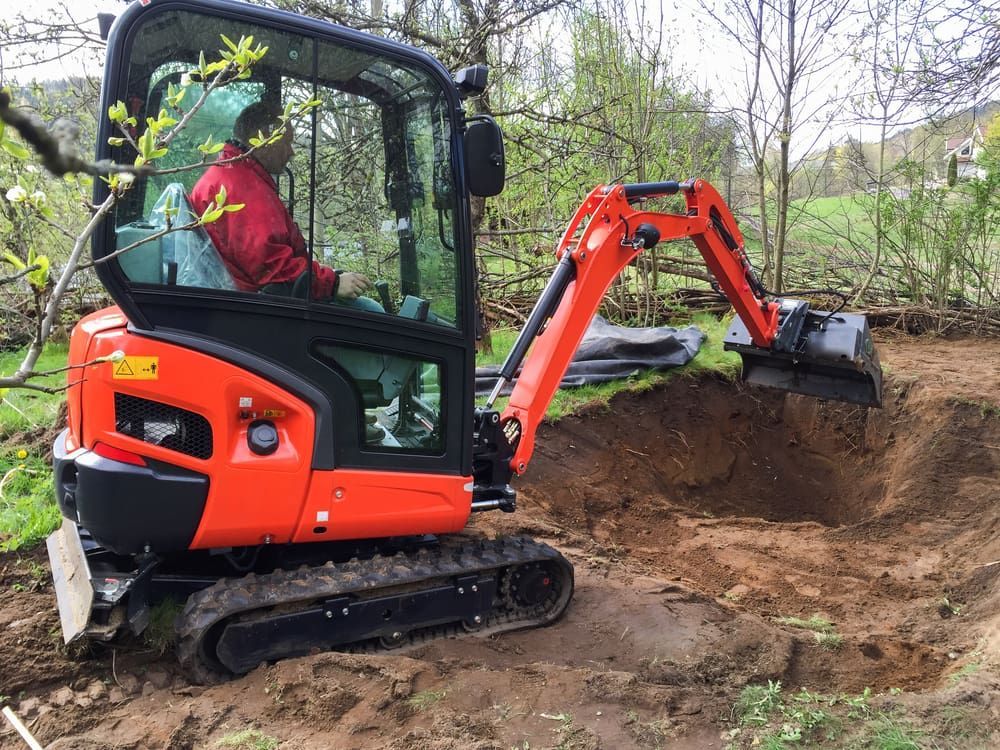 Man Operating an Orange Excavator Digging in a Dirt Area — Machinery & Equipment Hire in Trinity Beach, QLD