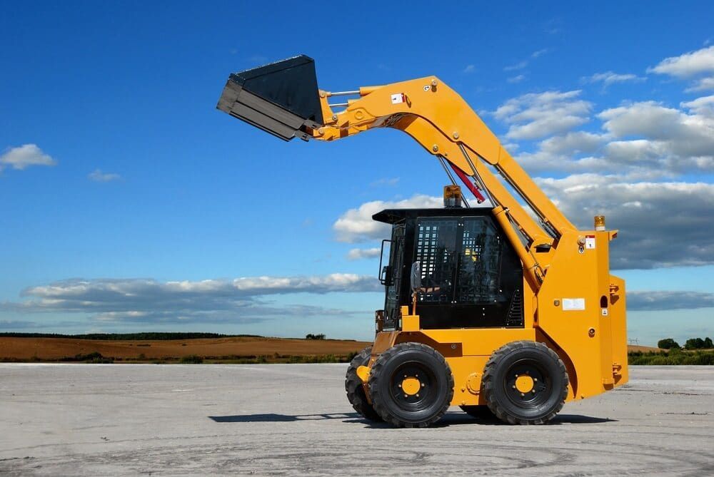 Yellow Skid Steer With Raised Bucket — Machinery & Equipment Hire in Trinity Beach, QLD