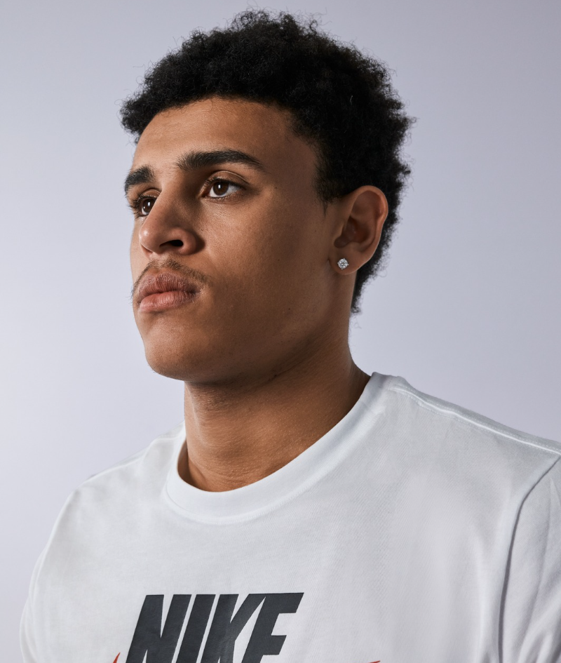Close up side profile studio portrait of Jaylen who wears a white Nike t-shirt.