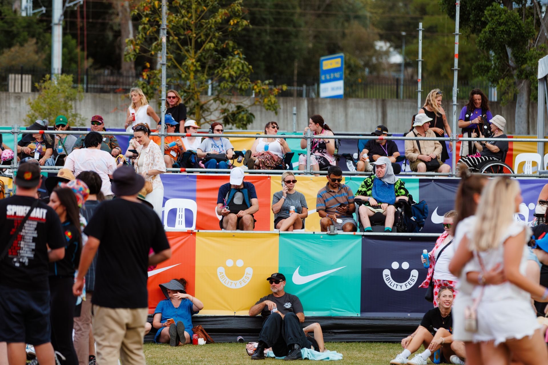 Day time photo at Ability Fest of the colourful branded Nike viewing platform. There are many patrons using the platform with some with mobility aids.