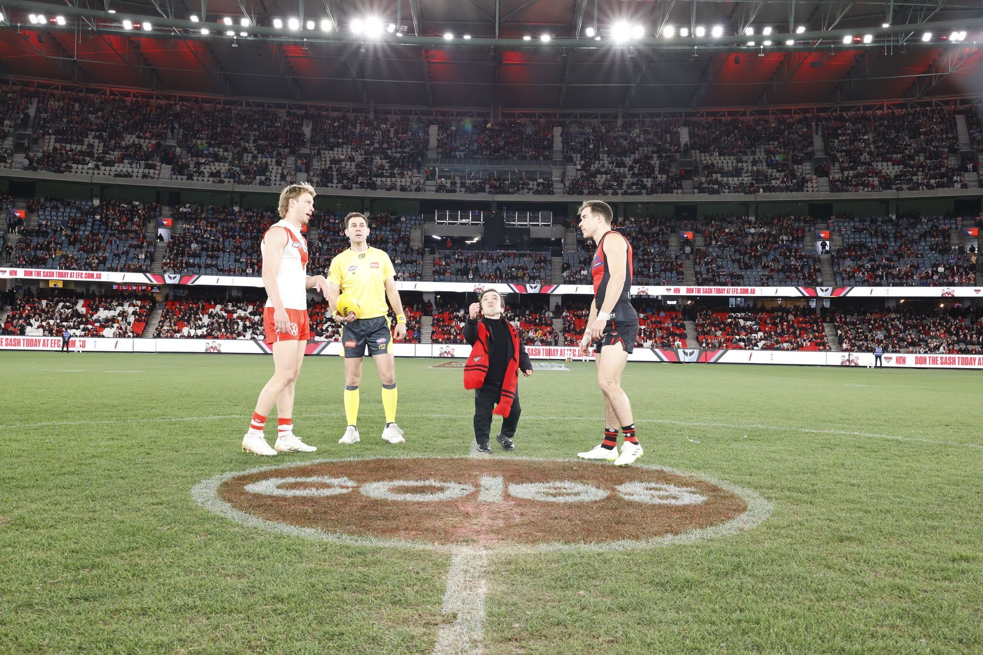 DAF representative who is short stature, mid coin toss between the captains of Essendon and Sydney. 