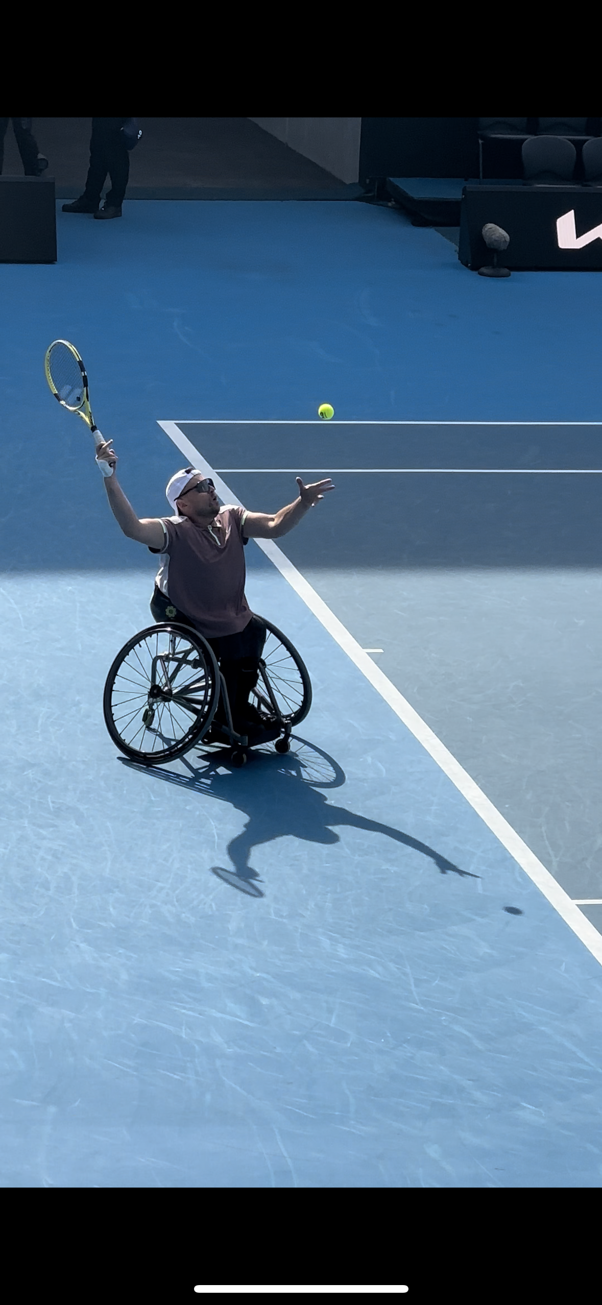 On court close up shot of Dylan mid tennis serve.