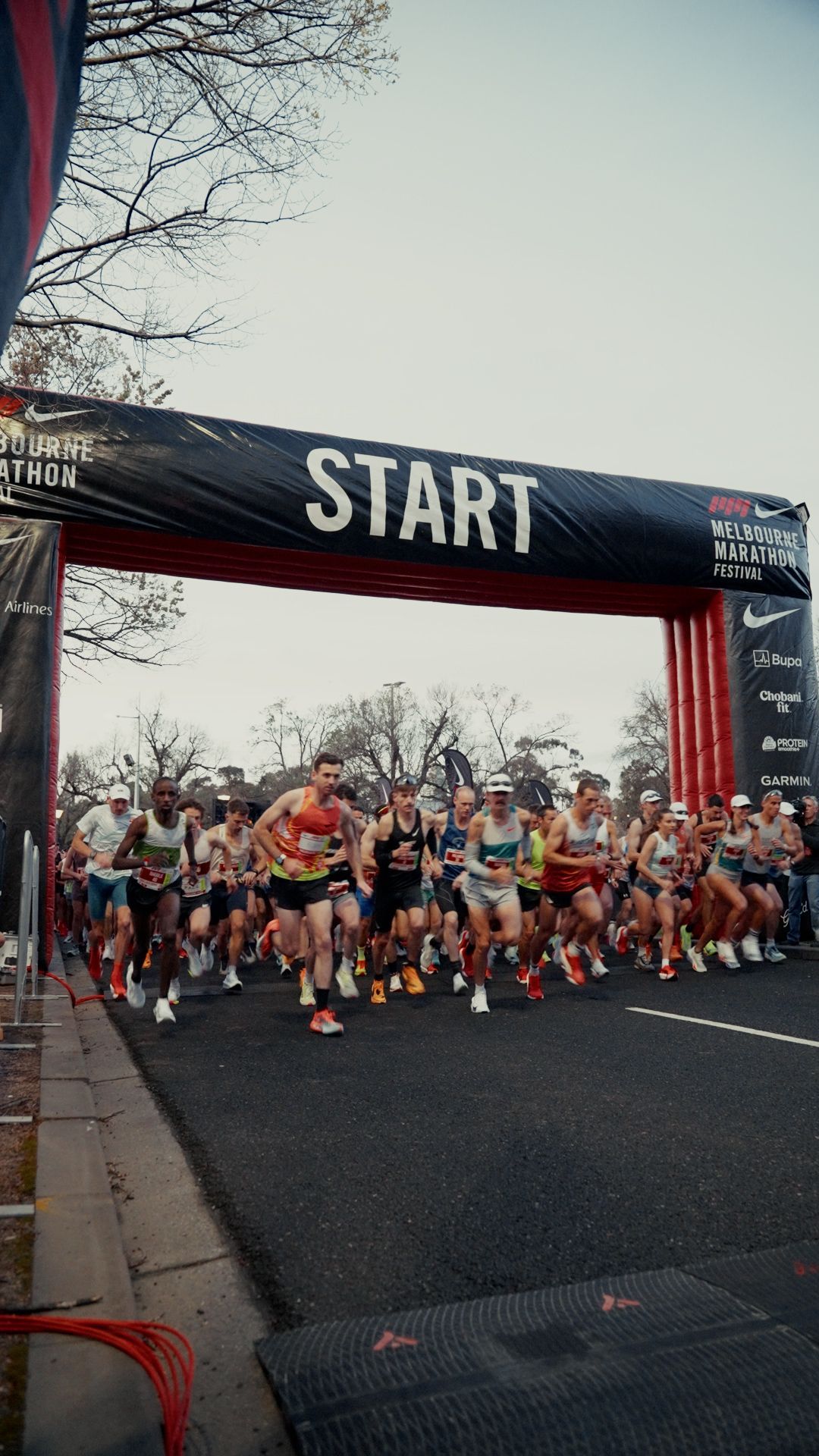 Large group of runners mid run, starting a marathon with start line above