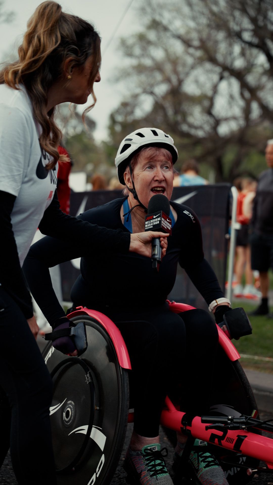 Media person interviewing a female athlete in a wheelchair