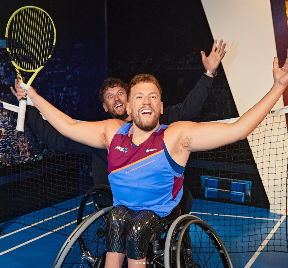 Real Dylan hiding and smiling behind wax figure tennis Dylan.