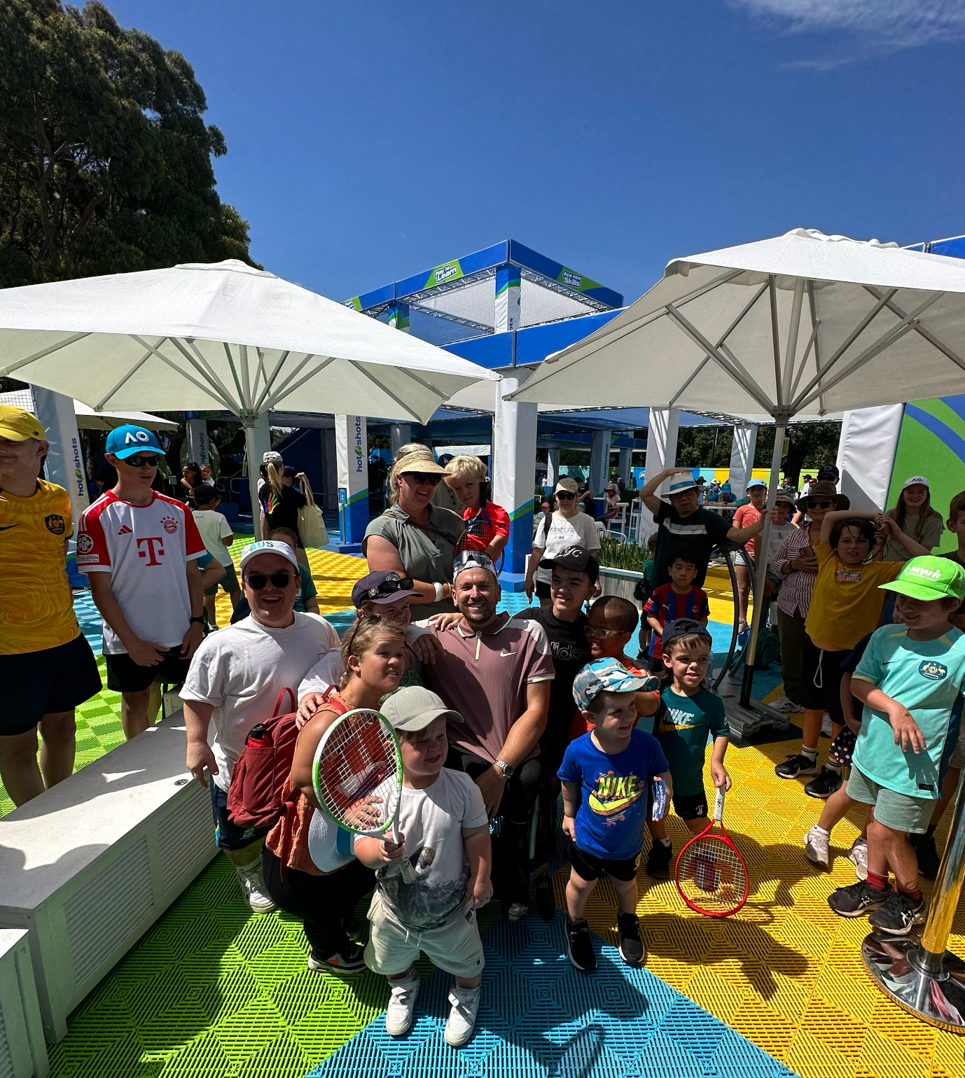 Dylan (middle) surrounded by people of all abilities at the AO ball park.