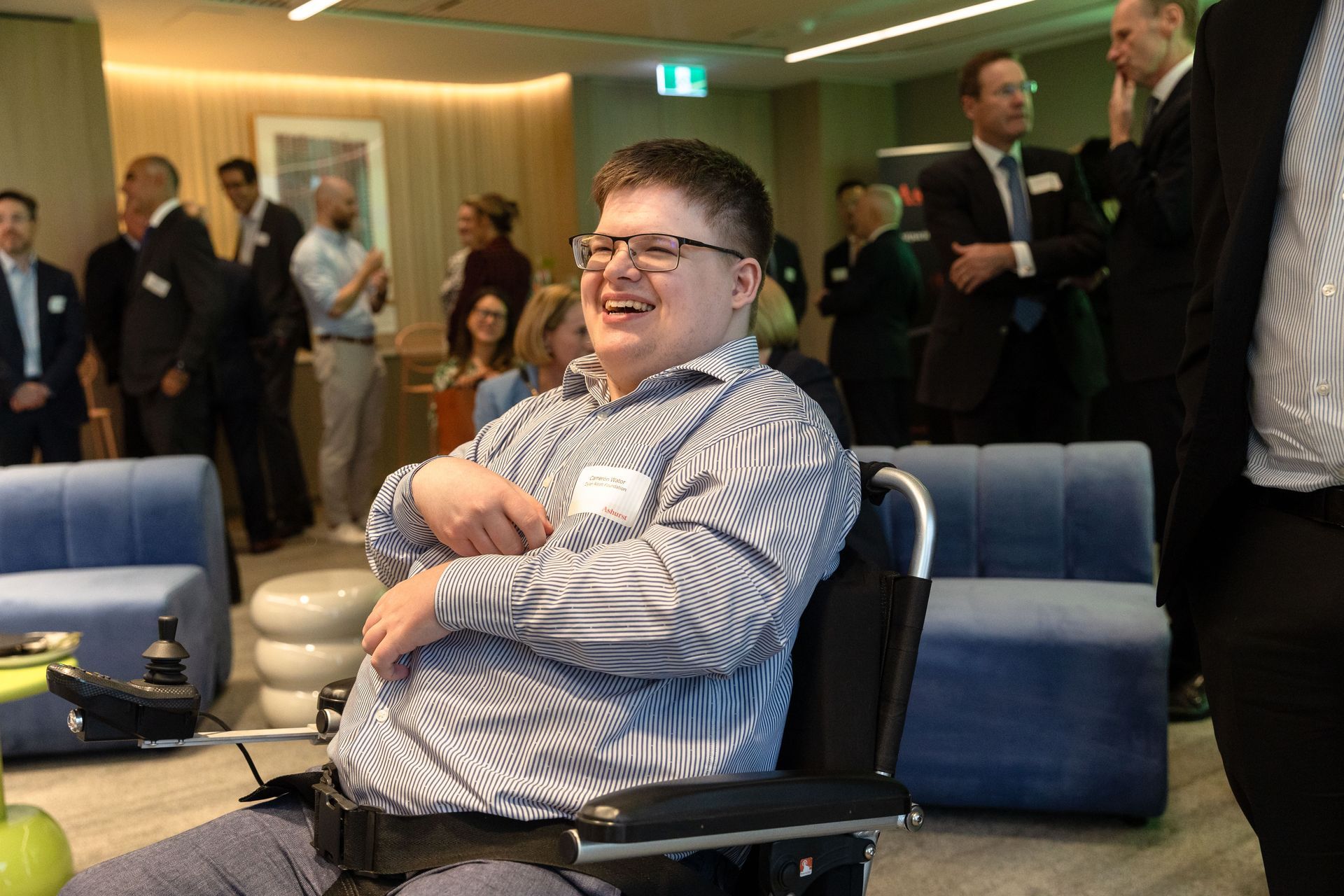 Recipient Cameron laughs and looks at panellists, he is sitting in his wheelchair. 