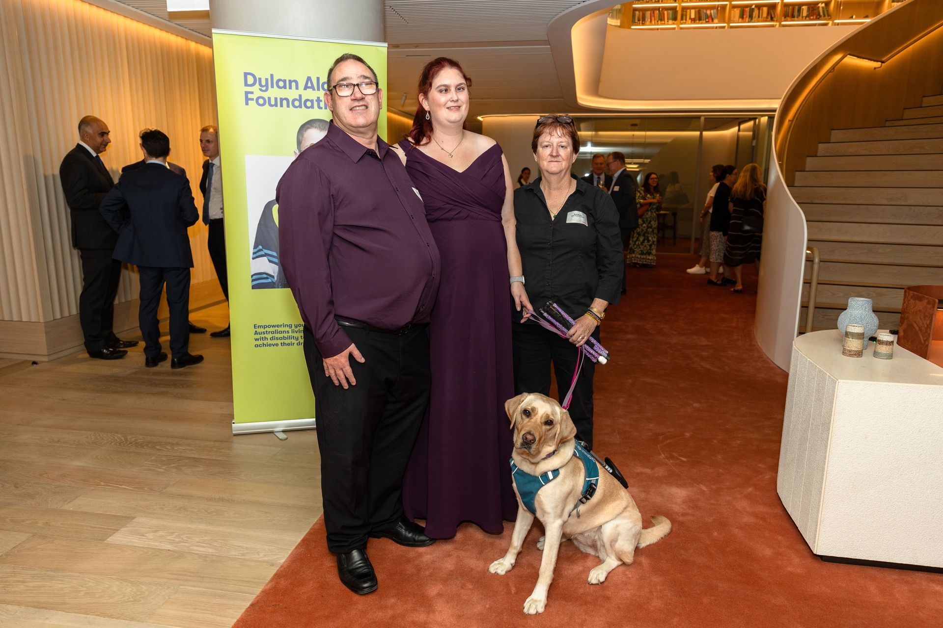 Group shot of Dustin (left), Kirsten (middle), Sue (right) and Kimba, Kirsten's guide dog in front.