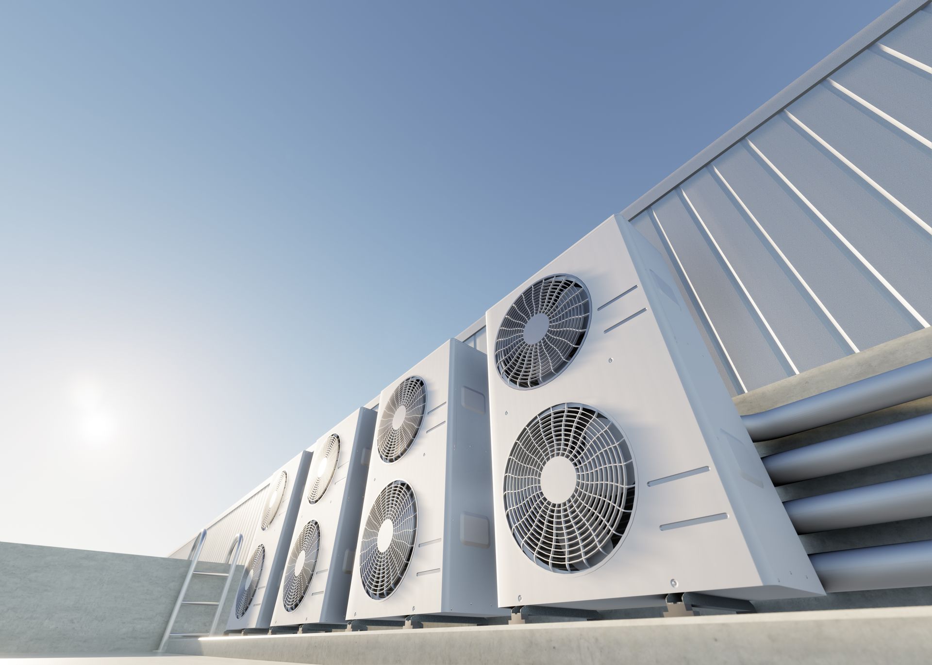 Air conditioning units on a rooftop against a clear blue sky.