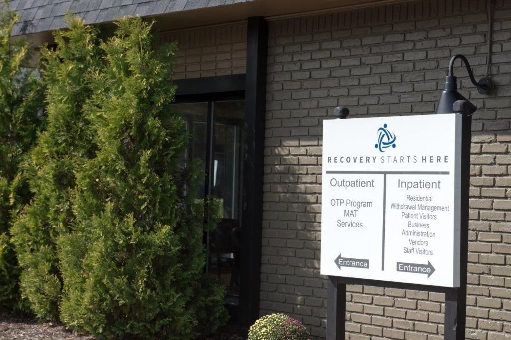 Sign for Malcom Perkins, office building entrance with directional arrows.