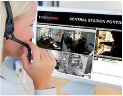 A woman wearing a headset is talking on a phone in front of a computer screen.