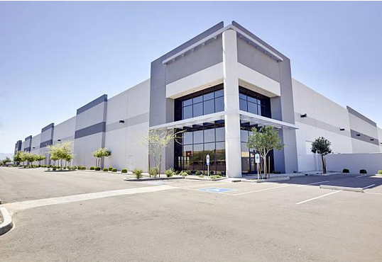 A large white building with a parking lot in front of it