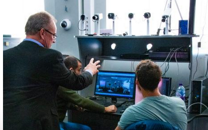 A man is teaching two men how to use a computer.