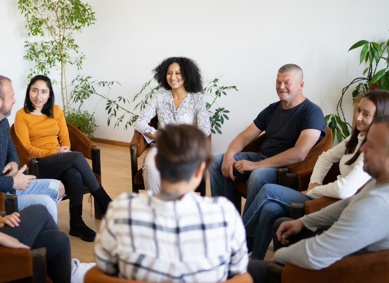 A man and a woman are sitting in chairs talking to each other.