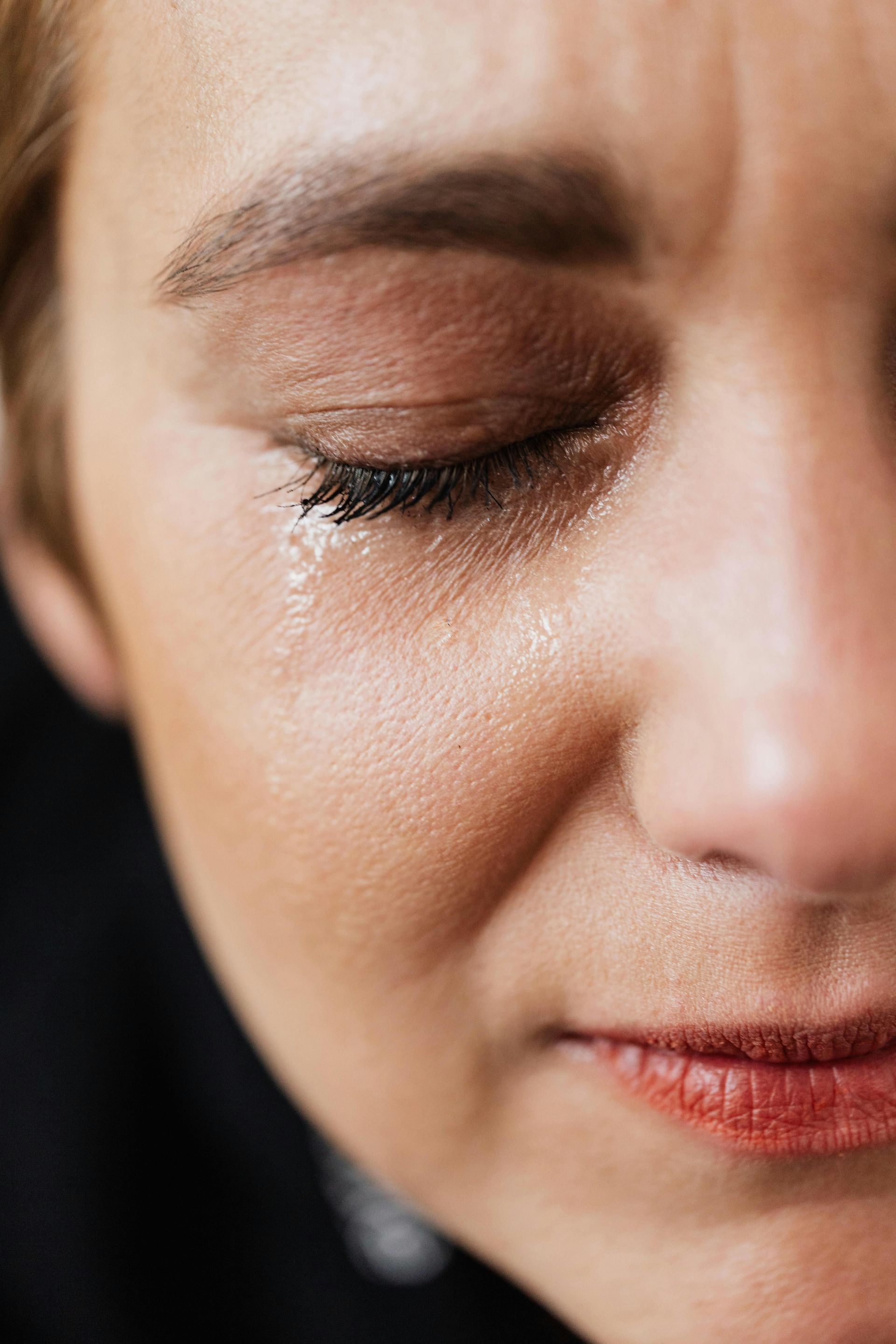 A close up of a woman 's face with her eyes closed.