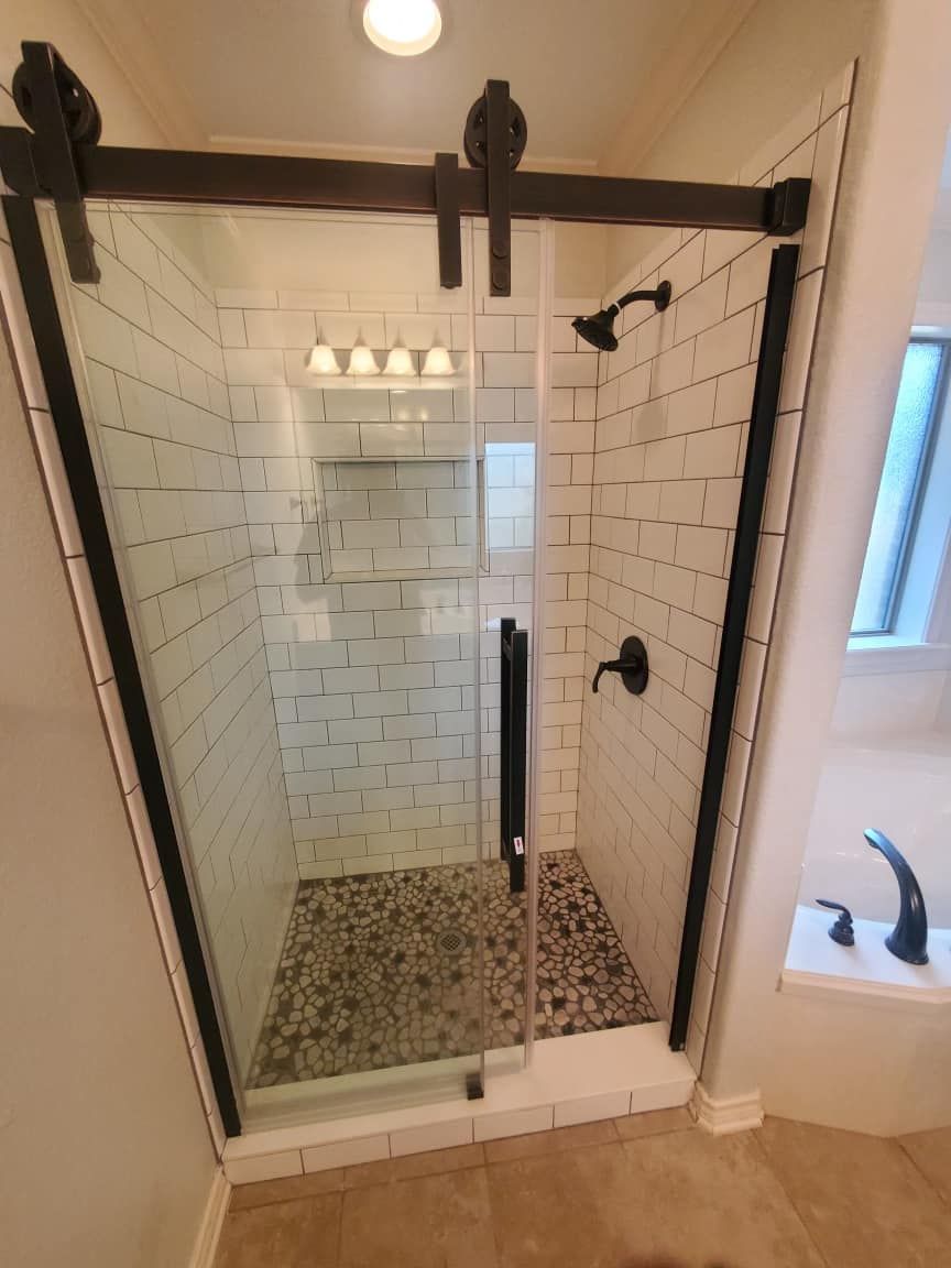 A bathroom with a sliding glass shower door.