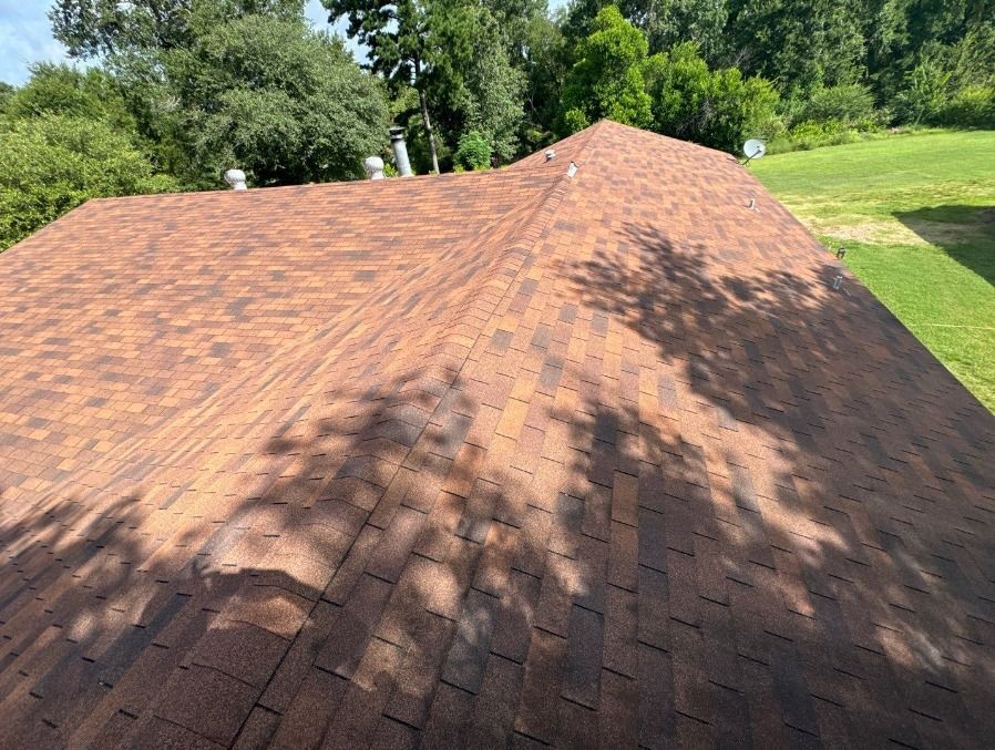 A close up of a roof with a shadow of trees on it.
