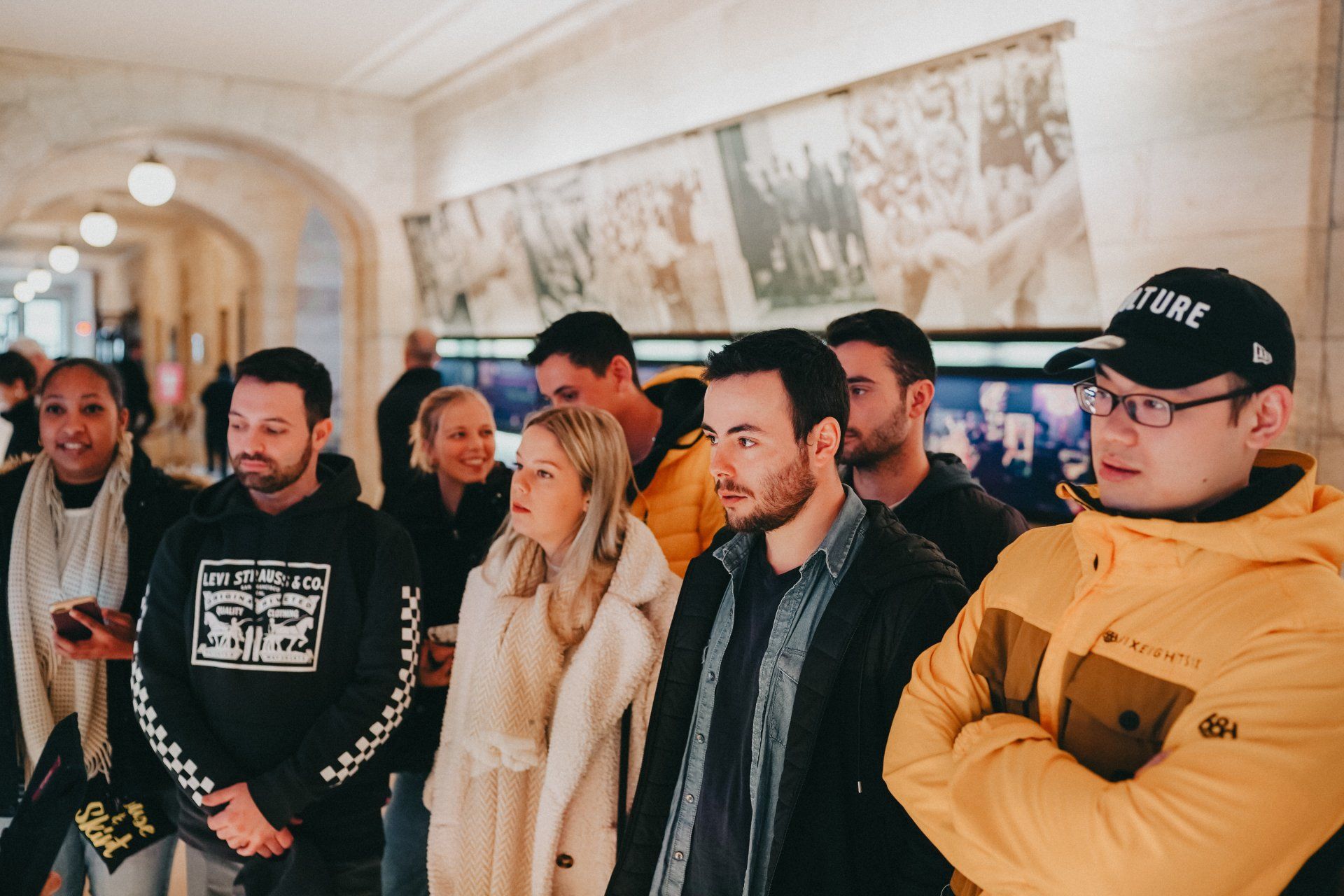A group of people are standing in a hallway.