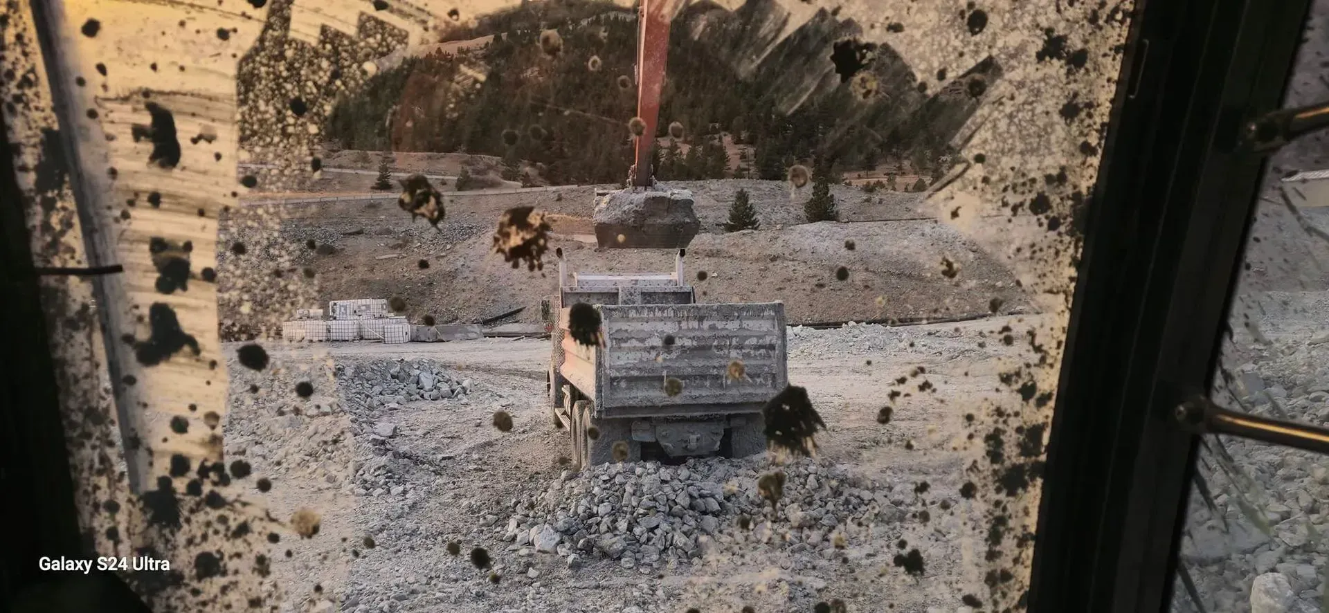 Aerial view of a destructed building, with scattered debris and dark spots, taken from a high angle.