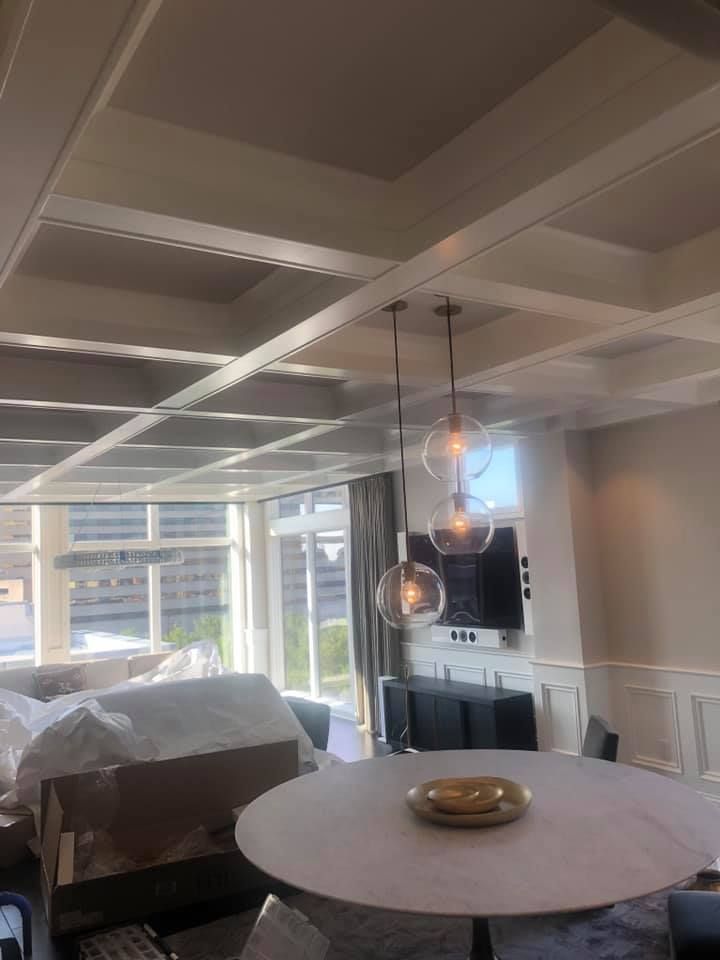 Dining area with round table, pendant lights, and a coffered ceiling.