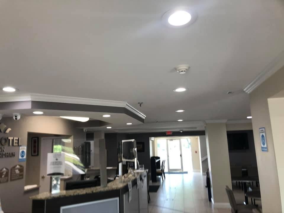 Hotel lobby with front desk, seating area, and doorway to the outside.