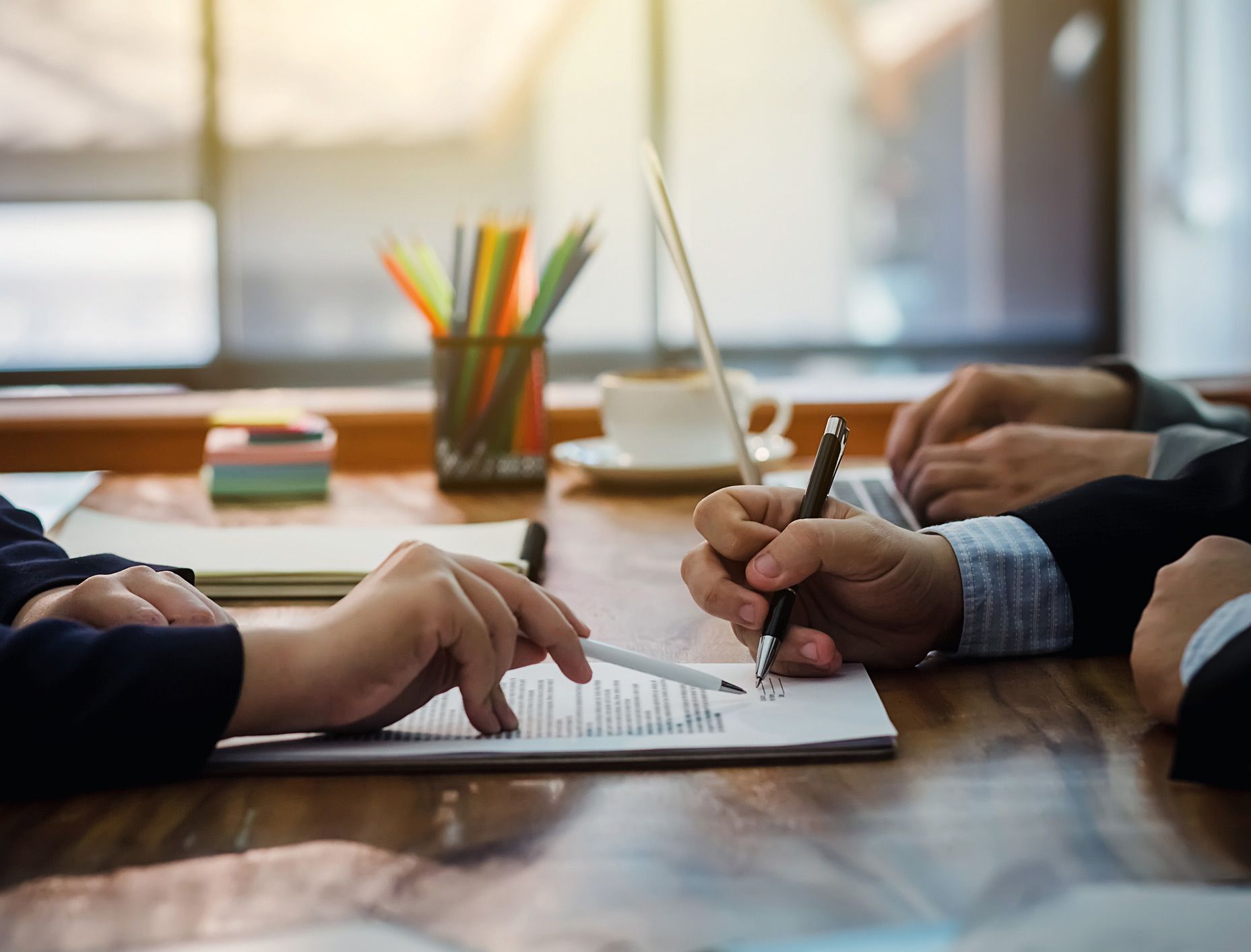 A group of people are sitting at a table looking at a piece of paper.