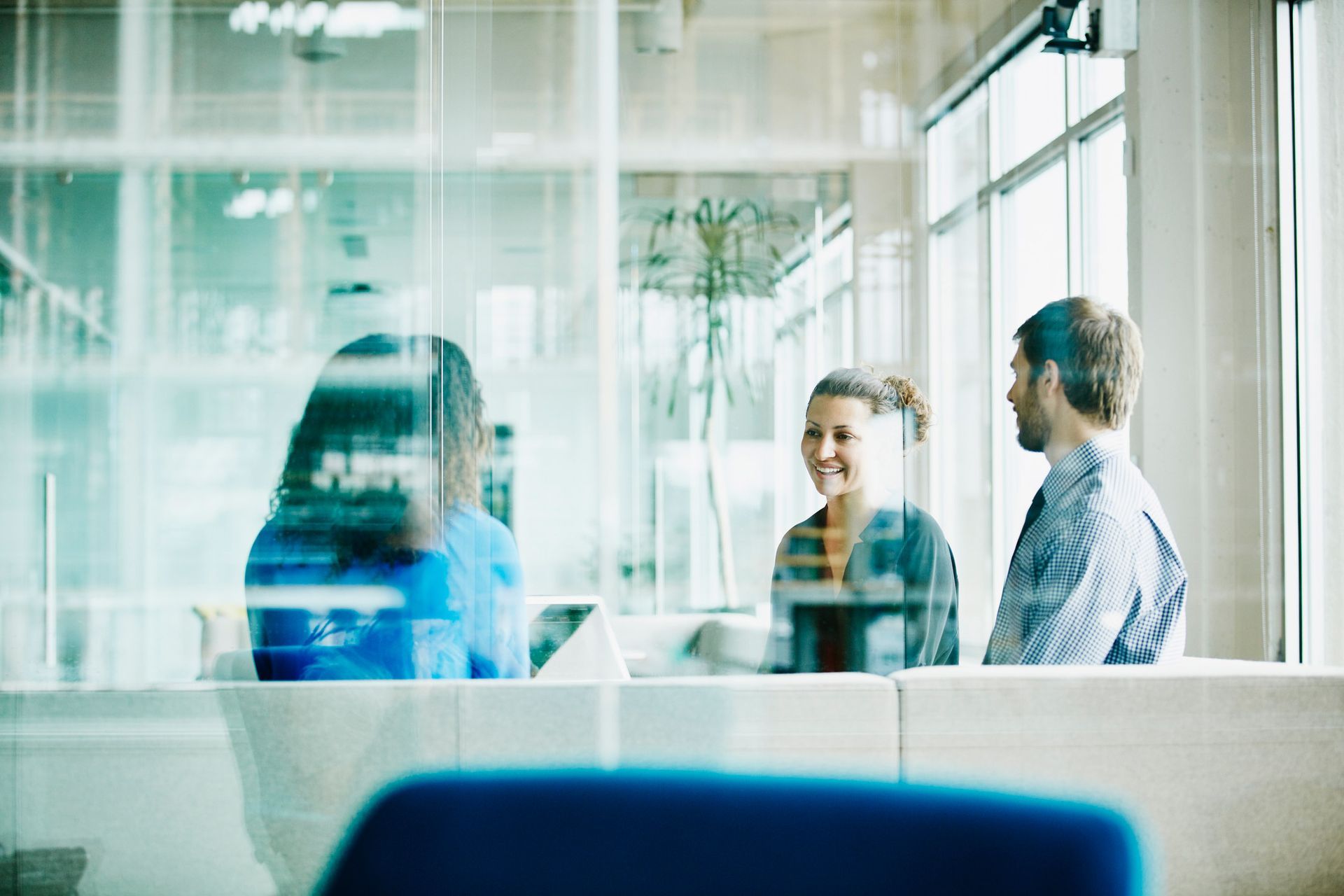 A group of people are sitting in a room talking to each other. A group of people are sitting in a room talking to each other.