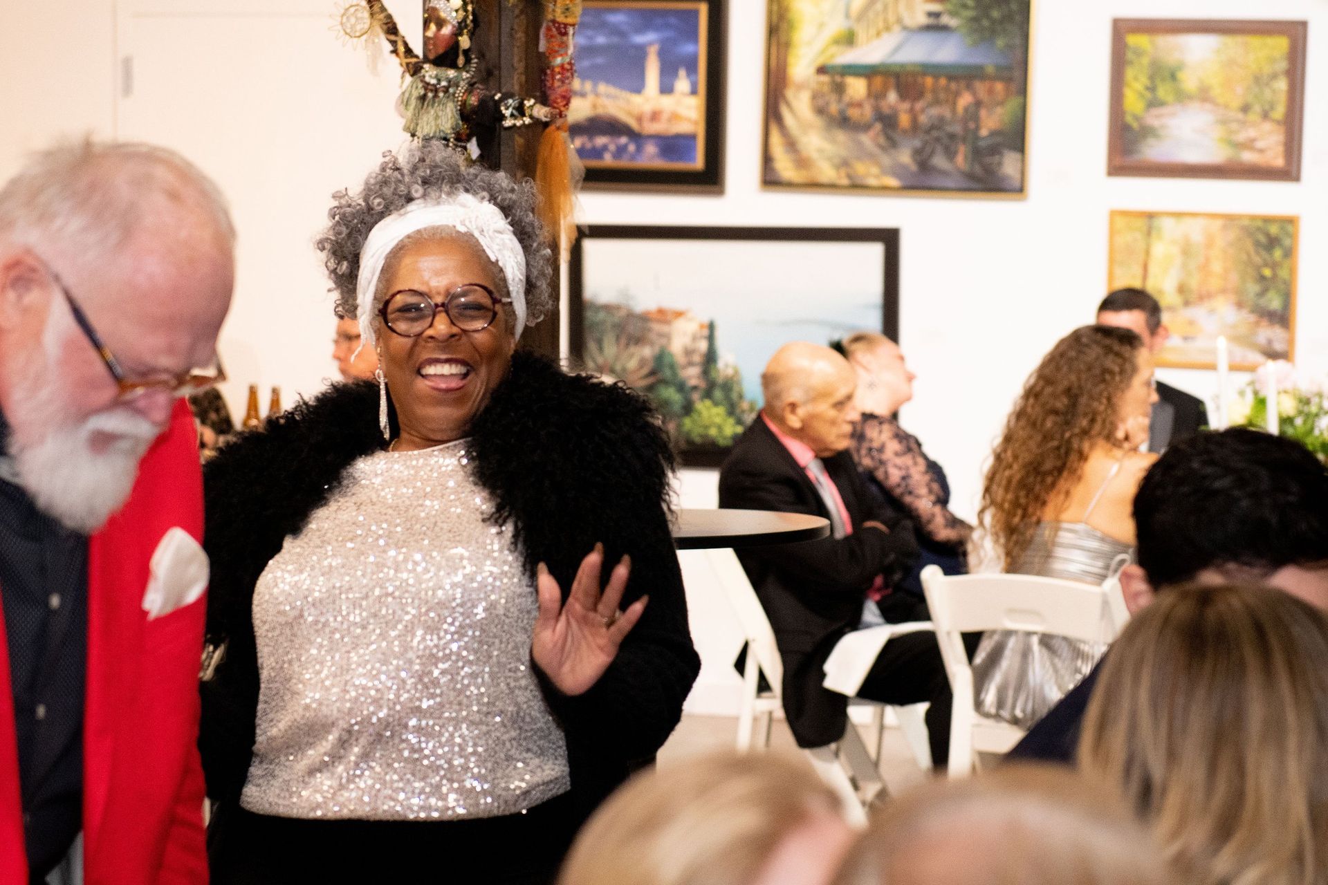 A woman is standing in front of a crowd of people in a room.