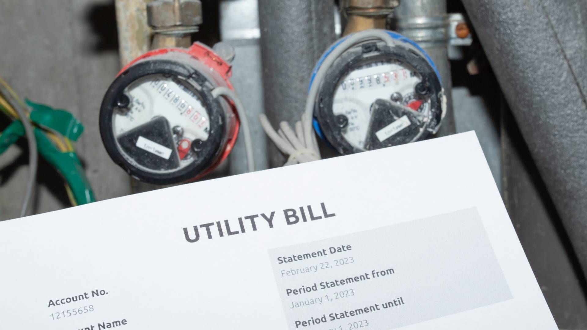 A utility bill in front of a water meter with one red and one blue knob at Epperson Inc. near Somers