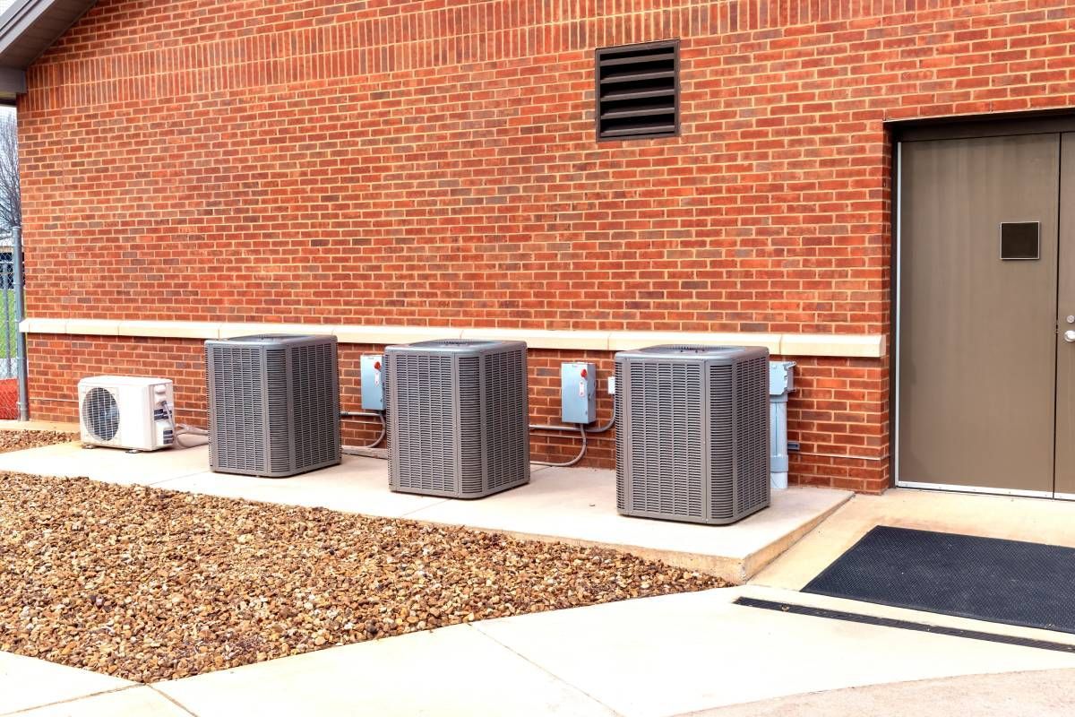 A photo of three well-maintained HVAC units outside of a brick school building near Somerset, KY