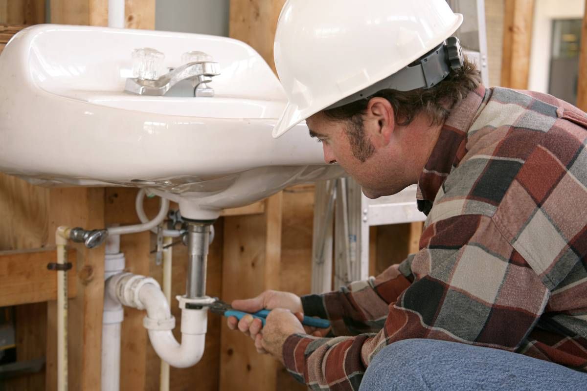 An expert plumbing technician working to install a sink for a new construction build near Somerset, KY