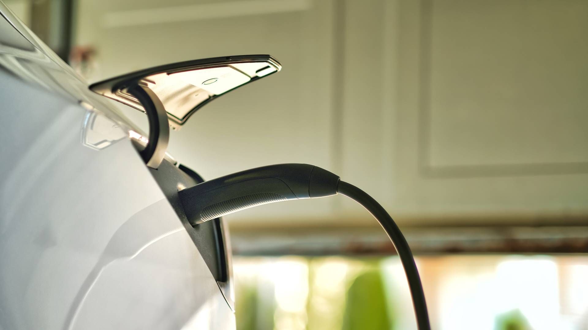 An at-home electric vehicle (EV) charger in a homeowner's garage, charging their EV for the day at E