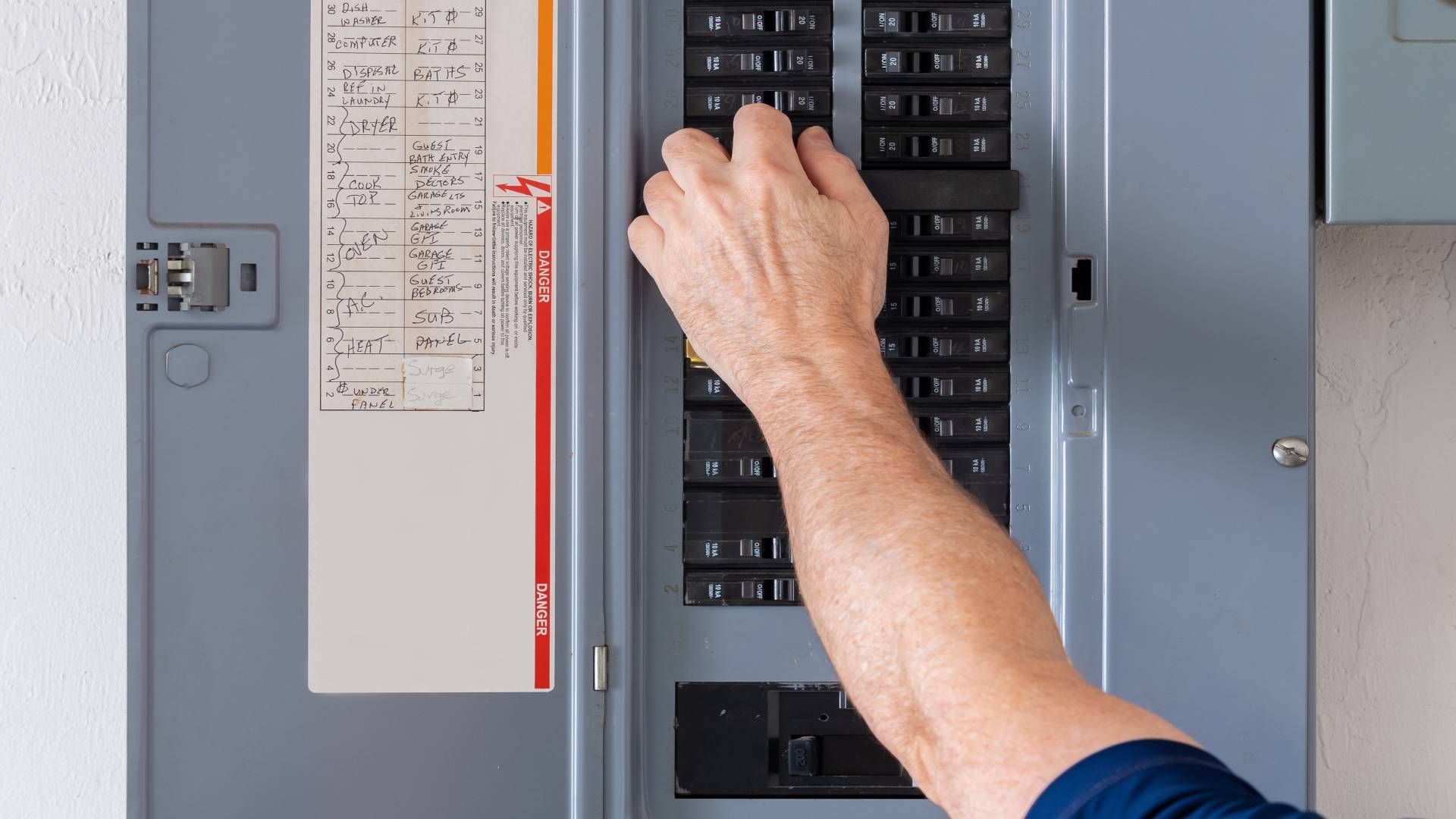 A professional inspecting the electrical panel for a circuit breaker upgrade in a client's home near