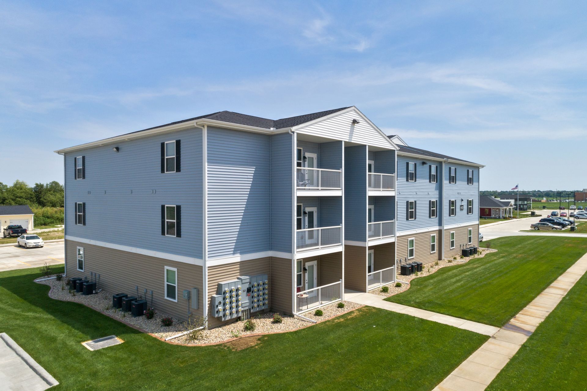 Windsor West - a park bench sits in front of a lake with apartments in the background