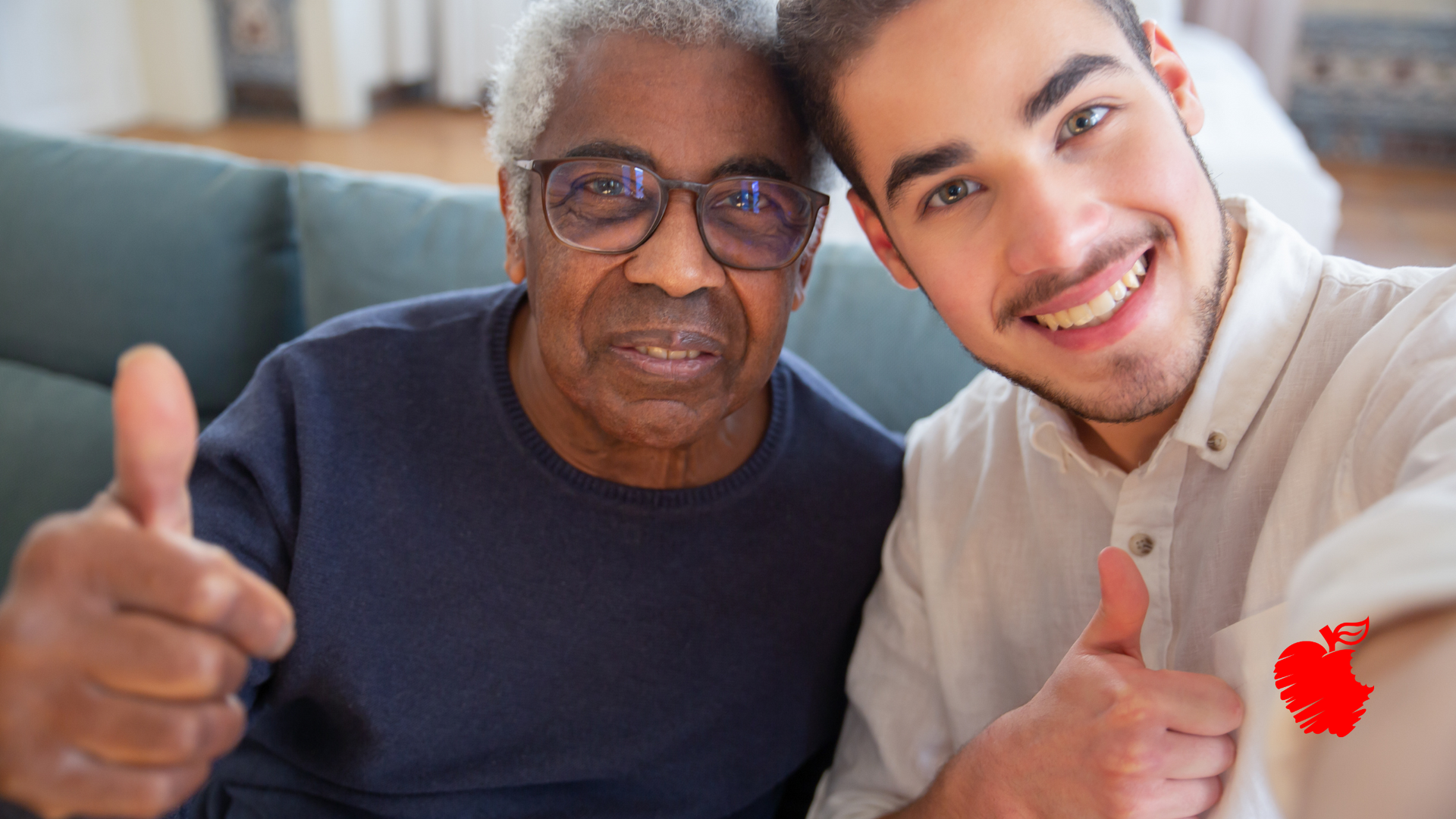 A young man is taking a selfie with an older man who is giving a thumbs up.