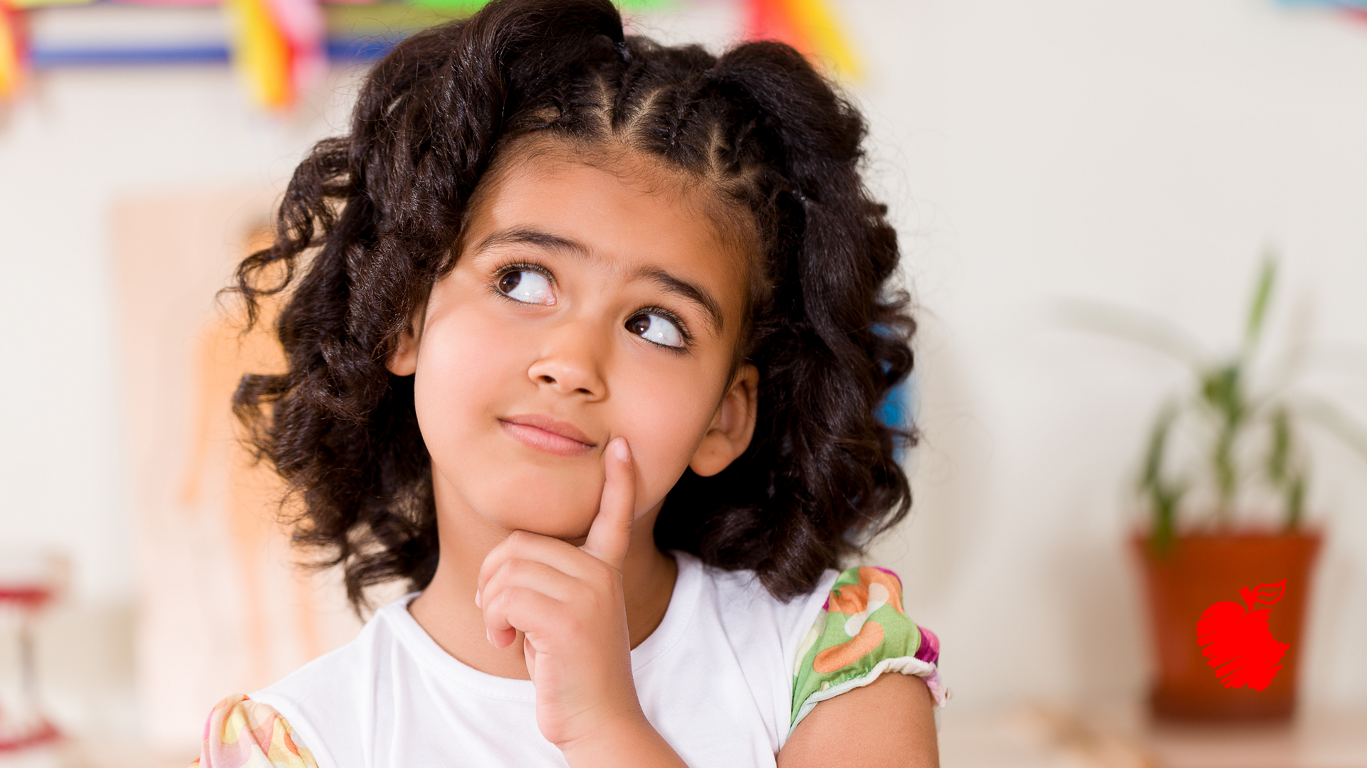 A little girl with curly hair is thinking with her hand on her chin.