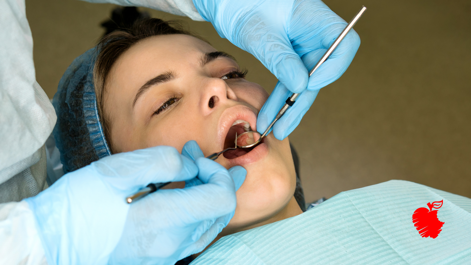 A woman is getting her teeth examined by a dentist.