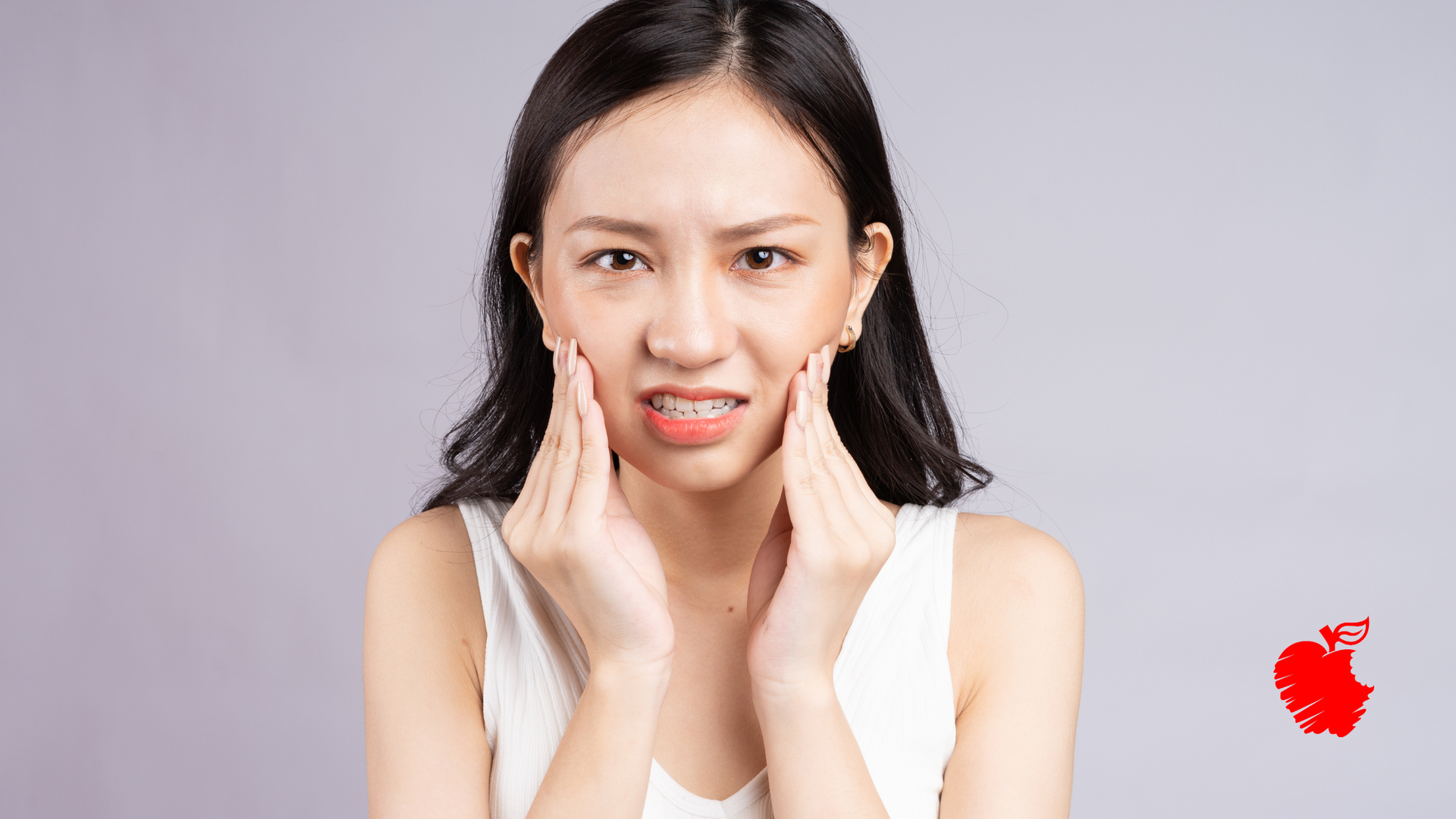 A woman is holding her face in pain because of a toothache.