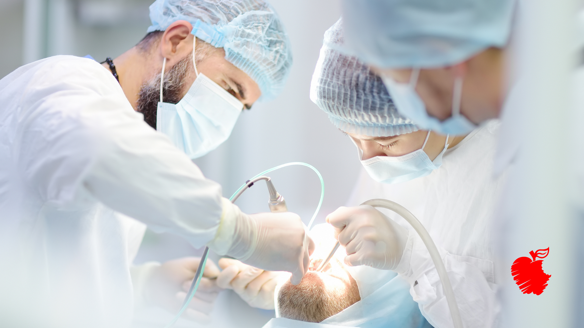 A group of surgeons are performing surgery on a patient in an operating room.