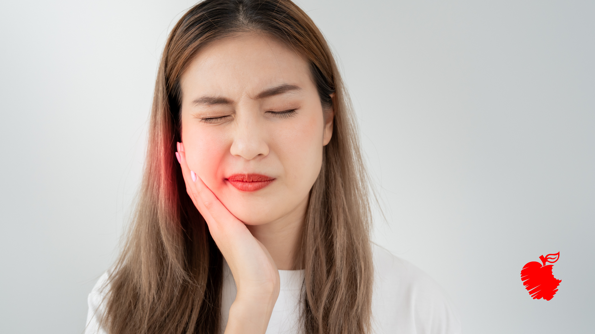 A woman is holding her face in pain because of a toothache.